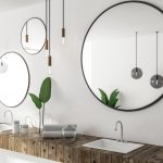 Double sink in wooden countertop in white bathroom interior with three round mirrors and panoramic window. Side view. 3d rendering